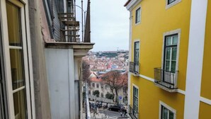 A narrow stairway leading to a yellow building with multiple windows and balconies. - Bairro Alto - 3 bedroom apartment with 2,5 bathrooms (Lisboa)