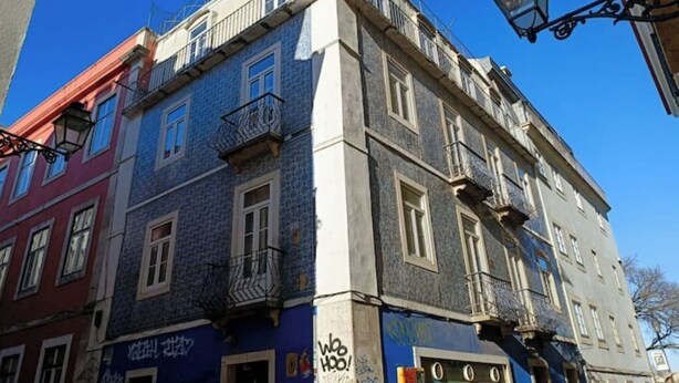 A multi-story building with a blue facade, balconies, and a visible storefront with signage. - Bairro Alto - 3 bedroom apartment with 2,5 bathrooms (Lisboa)