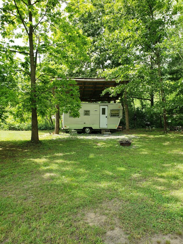 A green RV parked in a grassy area with trees around. - Primitive Fannie Camper by River & Kettle Creek pa Renovo Pa Westport Pa. (Westport)