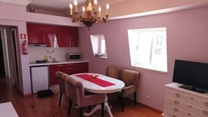 Een knus woongedeelte met een eethoek, kitchenette en een televisie.