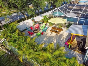 A patio area with outdoor furniture, a greenhouse, and a pool.