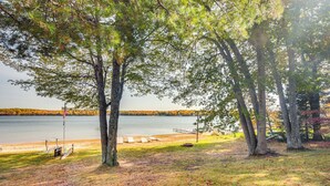 A lakeside park with trees, a dock, and a grassy area. - Lakefront Eagle River Cottage w/ Private Dock (Eagle River)