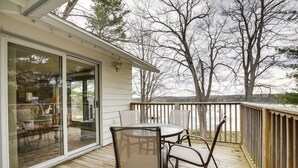 A wooden deck with a glass door leading to a living area. - Lakefront Eagle River Cottage w/ Private Dock (Eagle River)