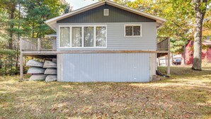 A small, single-story cabin with a covered porch and a garage. - Lakefront Eagle River Cottage w/ Private Dock (Eagle River)