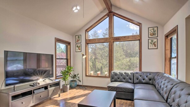 A modern living room with a large flat-screen TV, a grey sectional sofa, and a wooden floor. - Pine Mountain Club Getaway w/ Foosball Table! (Pine Mountain Club)