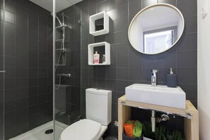 Chuveiro, secador de cabelo, toalhas de banho, papel higiênico
