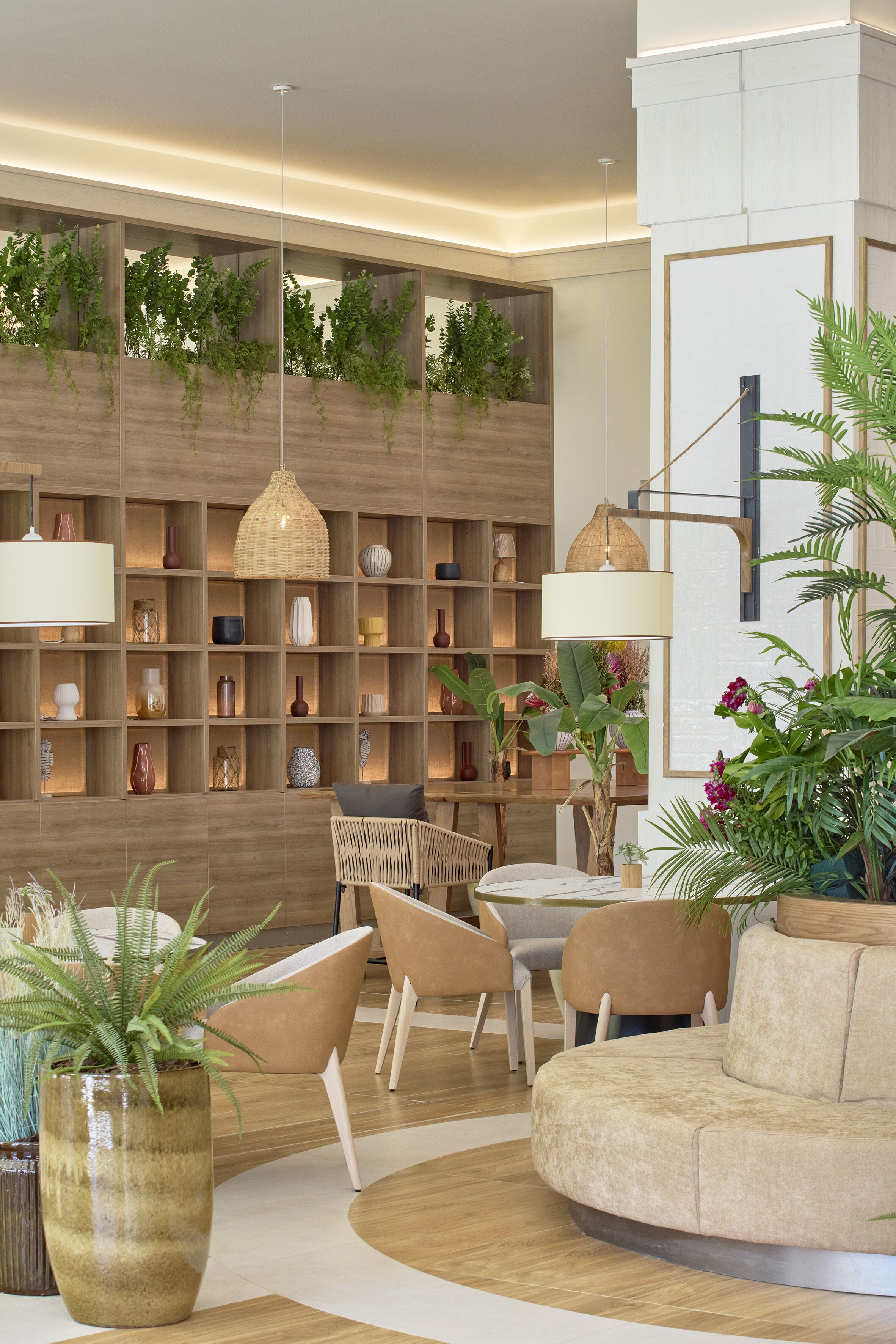 Un interior moderno con una estantería de madera, un sofá redondo color beige y una mesa de comedor con sillas.
