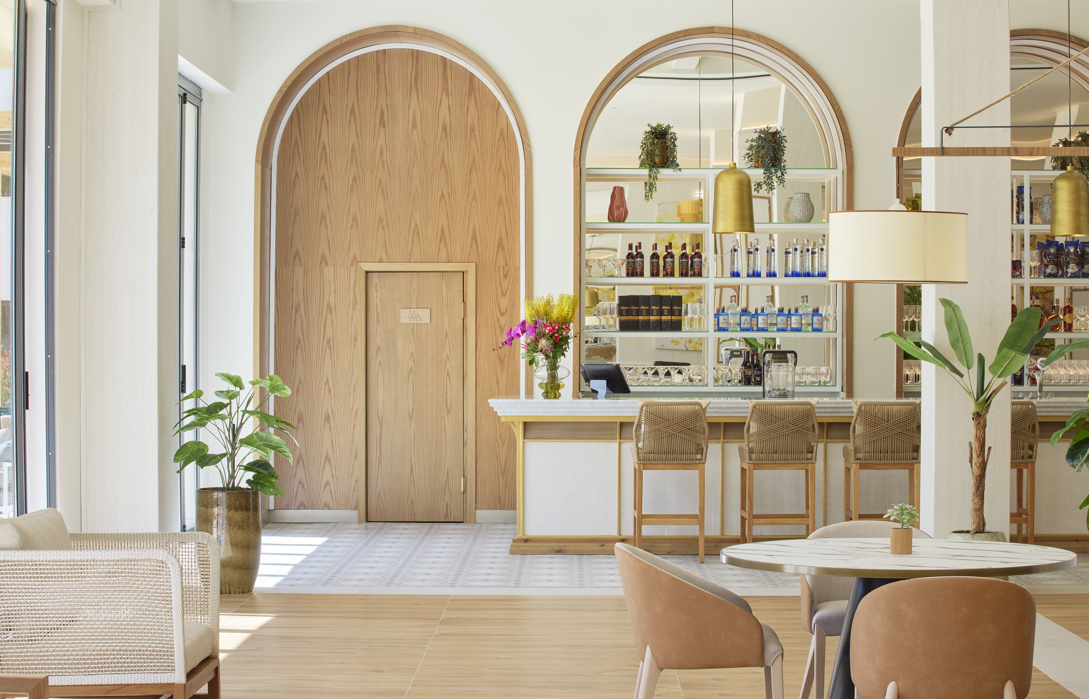 A modern interior with a bar area, seating, and a large wooden door.