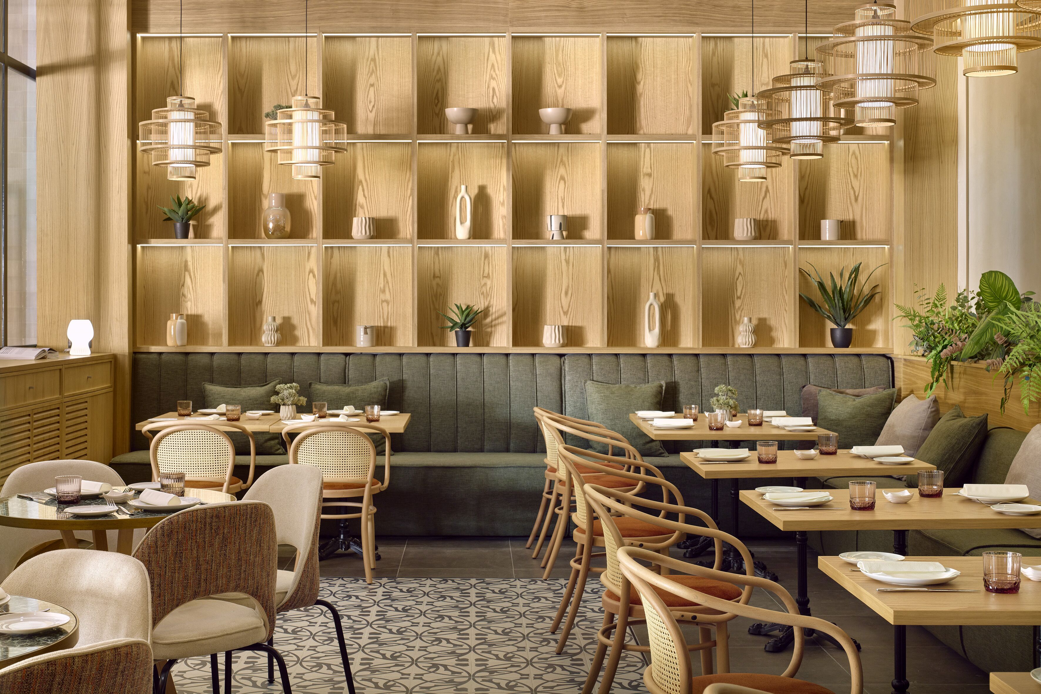 En restaurant med træpanelerede vægge, flere spiseborde og stole.