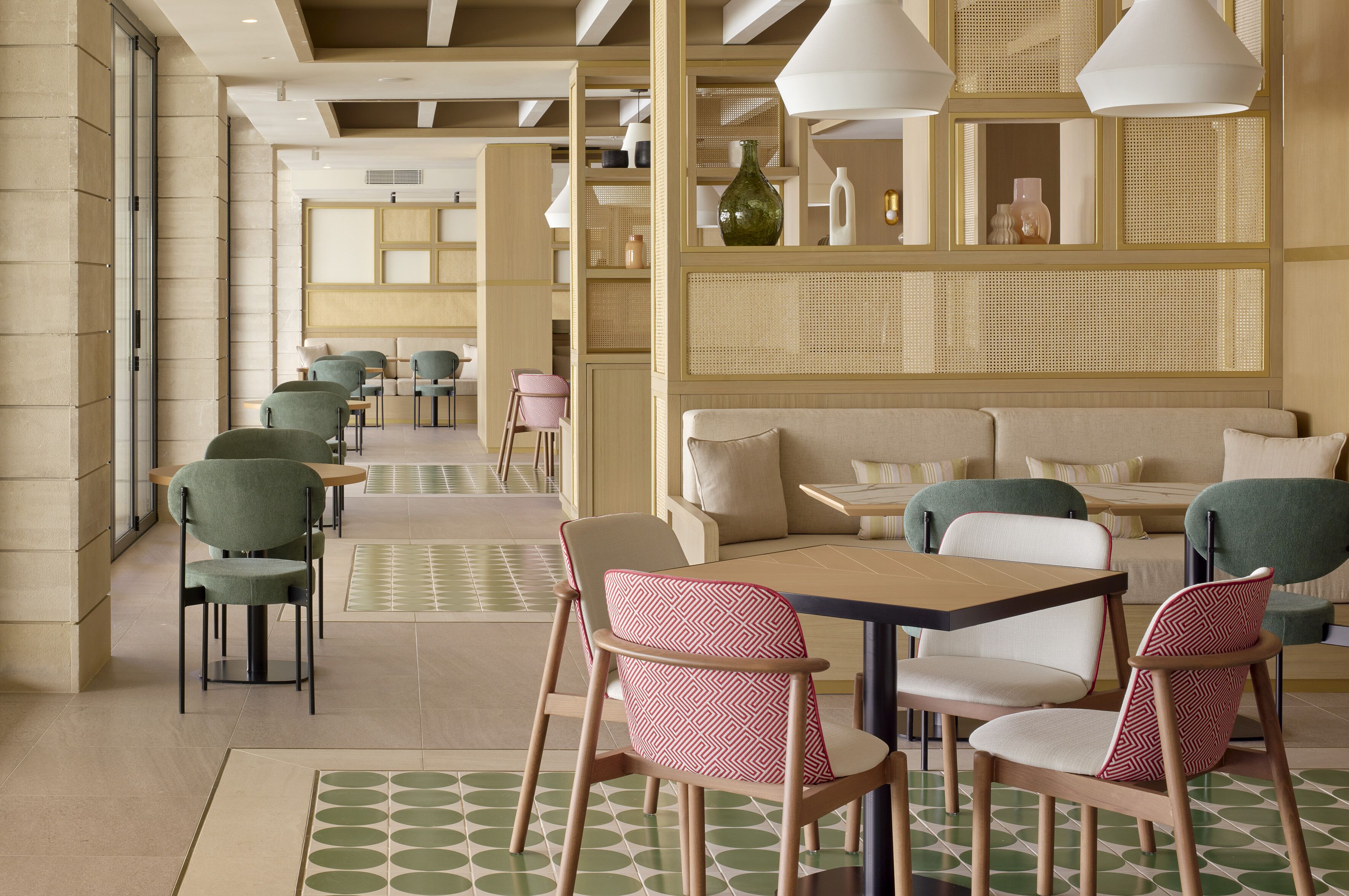 A modern restaurant with a long counter, multiple seating areas, and a decorative wall with shelves.