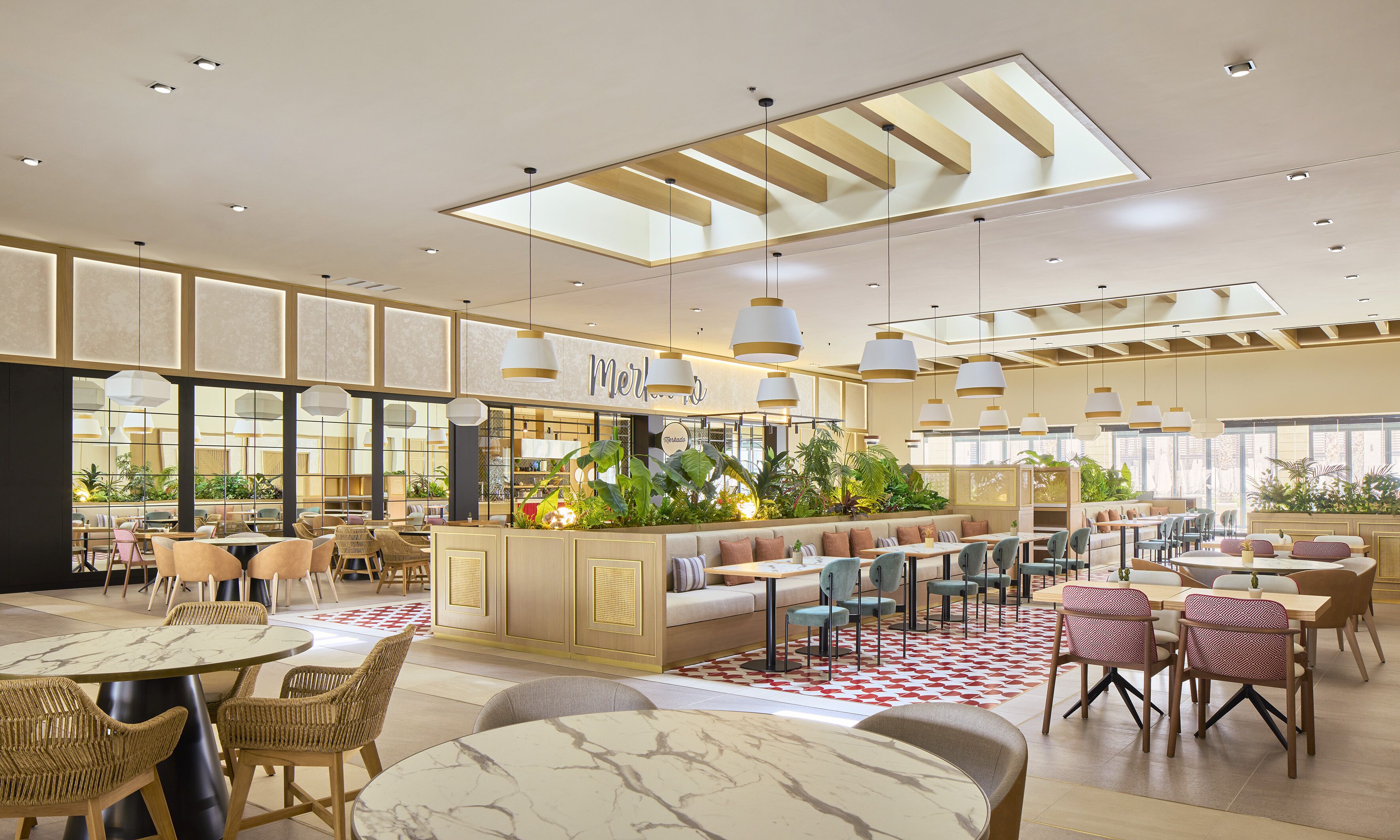 Un restaurant spacieux avec de hauts plafonds, de grandes fenêtres et un espace de restauration central doté d’un bar.