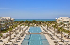 A resort with a central swimming pool, palm trees, and a view of the sea. - Melia Durres Albania (Ishëm)