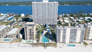 Un hôtel de grande hauteur, avec de nombreux étages, une piscine et une vue sur la plage.