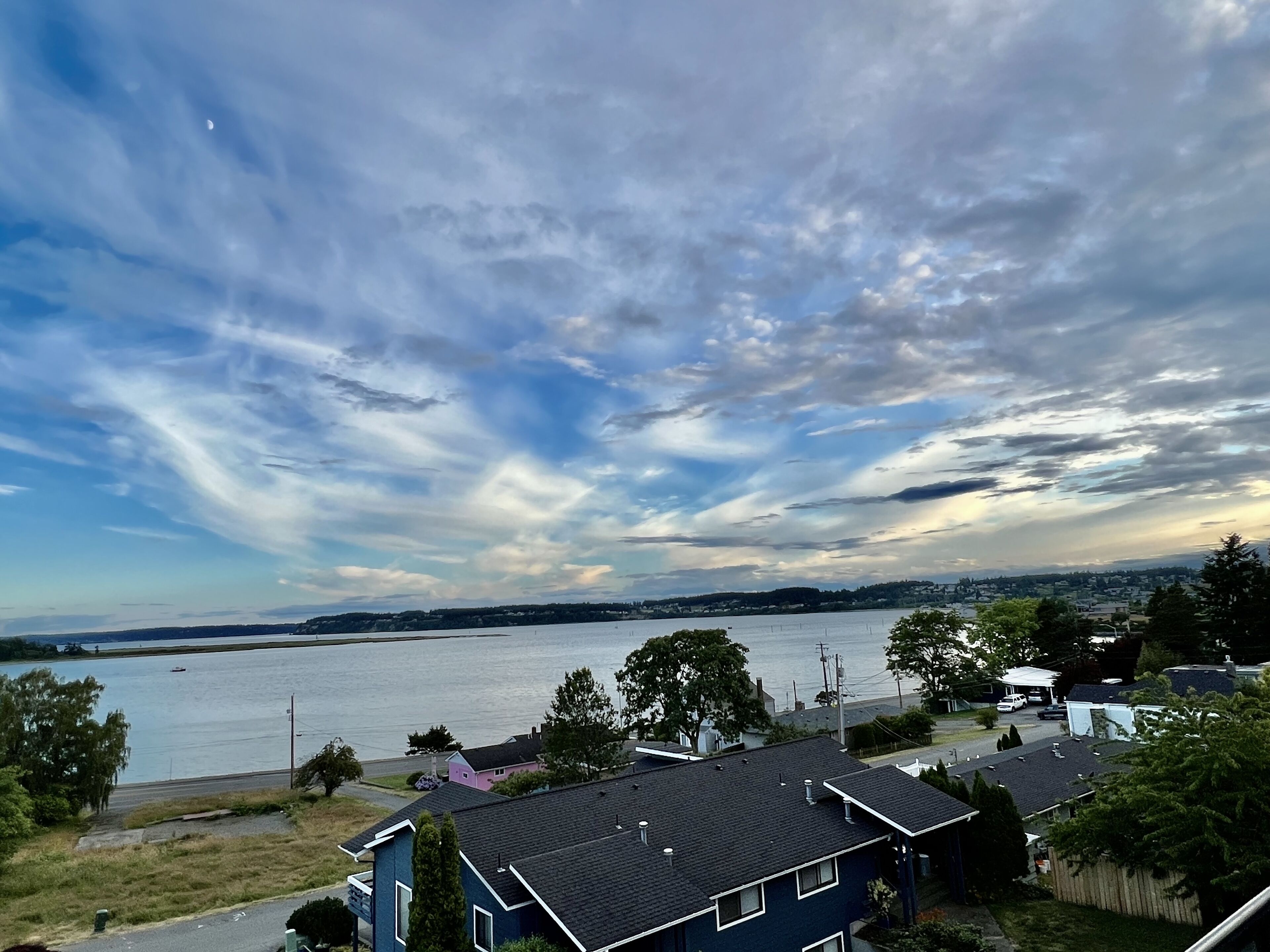 A residential area with houses near a body of water, under a cloudy sky.