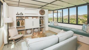 A modern living room with a sofa, a chair, a coffee table, and a bookshelf.