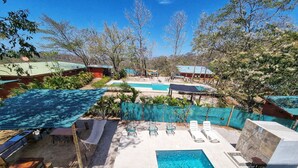 Ein Poolbereich mit mehreren Pools, Liegestühlen und einem kleinen Tisch.