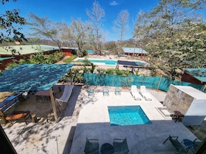 A pool area with multiple pools, lounge chairs, and a small table. - Casa Illimani pool side gorgeous mountain ocean views from hilltop (Pinilla)