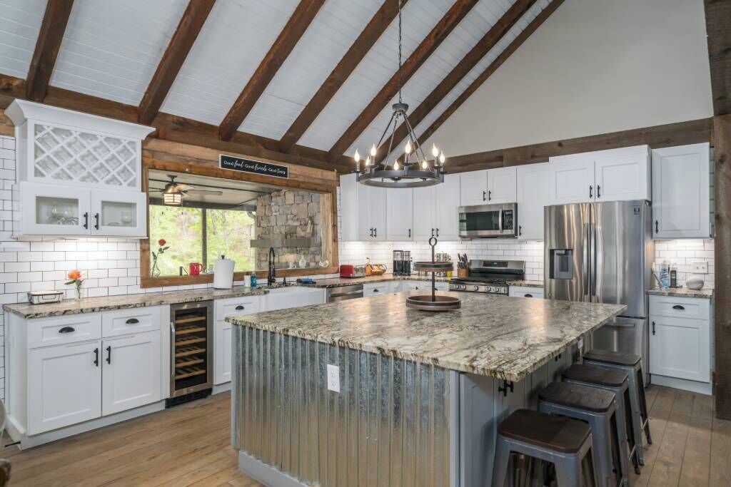 A spacious kitchen with a large island, white cabinetry, and stainless steel appliances.