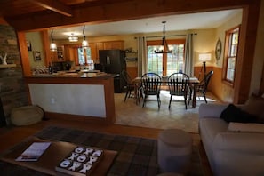 A cozy kitchen with wooden cabinets, a dining area with a table and chairs, and a living room with a sofa.