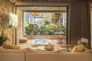 A spa area with a hot tub, seating, and a view of greenery. - Hotel Aimarawa (San Antero)