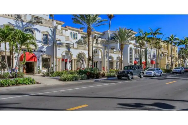 A street with buildings, palm trees, and parked cars. - Close to parks, beaches and downtown Naples (Naples)