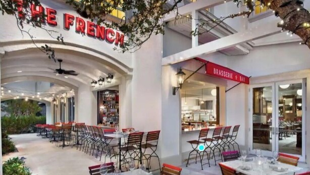 An outdoor dining area with tables and chairs, a sign reading "THE FRENCH," and a "BRASSERIE + BAR" sign. - Stylish 2 bedroom Close to beaches, parks and downtown Naples (Naples)