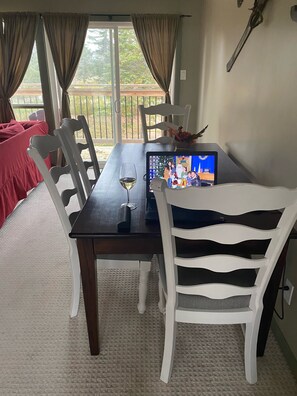 Guests can dine in comfort with a table set for two, featuring a laptop, wine, and decorative accents.