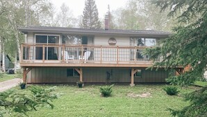 A two-story building with a balcony, a sign reading "COTTAGE," and a small front yard with grass and shrubs. - Hideaway in The Blue Mountains ***all seasons*** (The Blue Mountains)