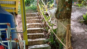 Une série de marches en béton menant à une structure en bois dotée d’une rambarde en métal.