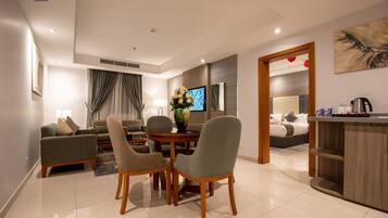 Suite familiar | Área de sala de estar | Smart TV de 50 pulgadas con canales vía satélite y televisión