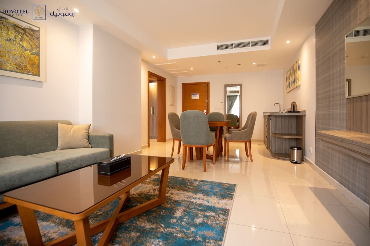 Une chambre d’hôtel moderne dotée d’un espace salon, d’un coin repas et d’une kitchenette.