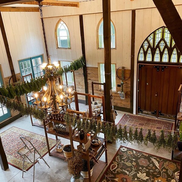 A spacious interior with high ceilings, wooden beams, and large windows.
