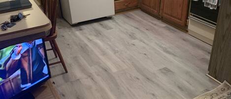 Una cocina con armarios de madera, un refrigerador, un fregadero y un comedor con mesa y sillas.