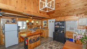 L’intérieur d’une cabane en bois comprend une cuisine, un coin repas et un îlot central.