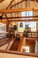 Uma escadaria com guarda-corpos de madeira e luminárias pendentes de metal.