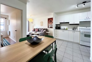 A modern kitchen with white cabinets, a microwave, and a stove.