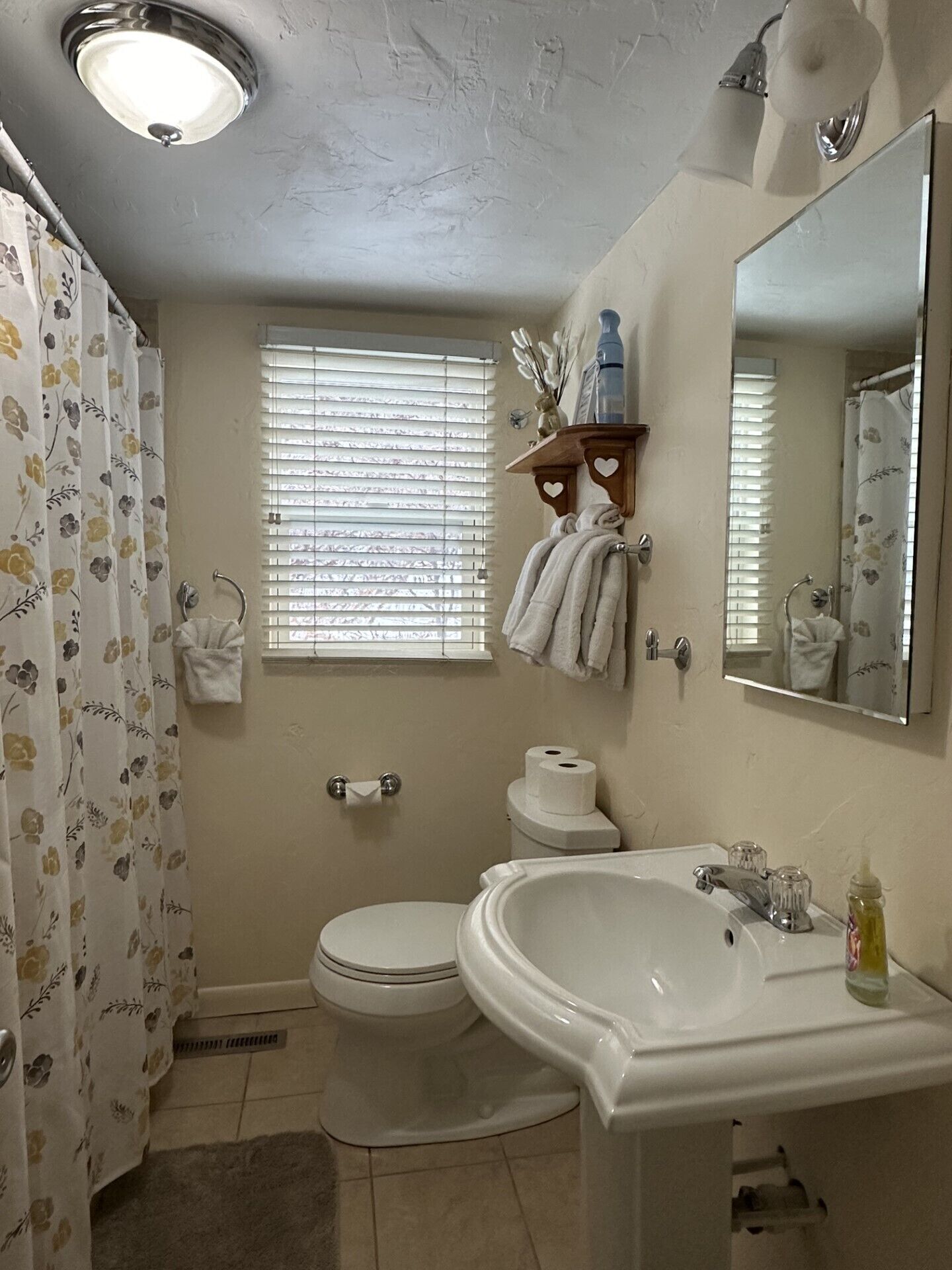 A bathroom with a toilet, sink, and shower.