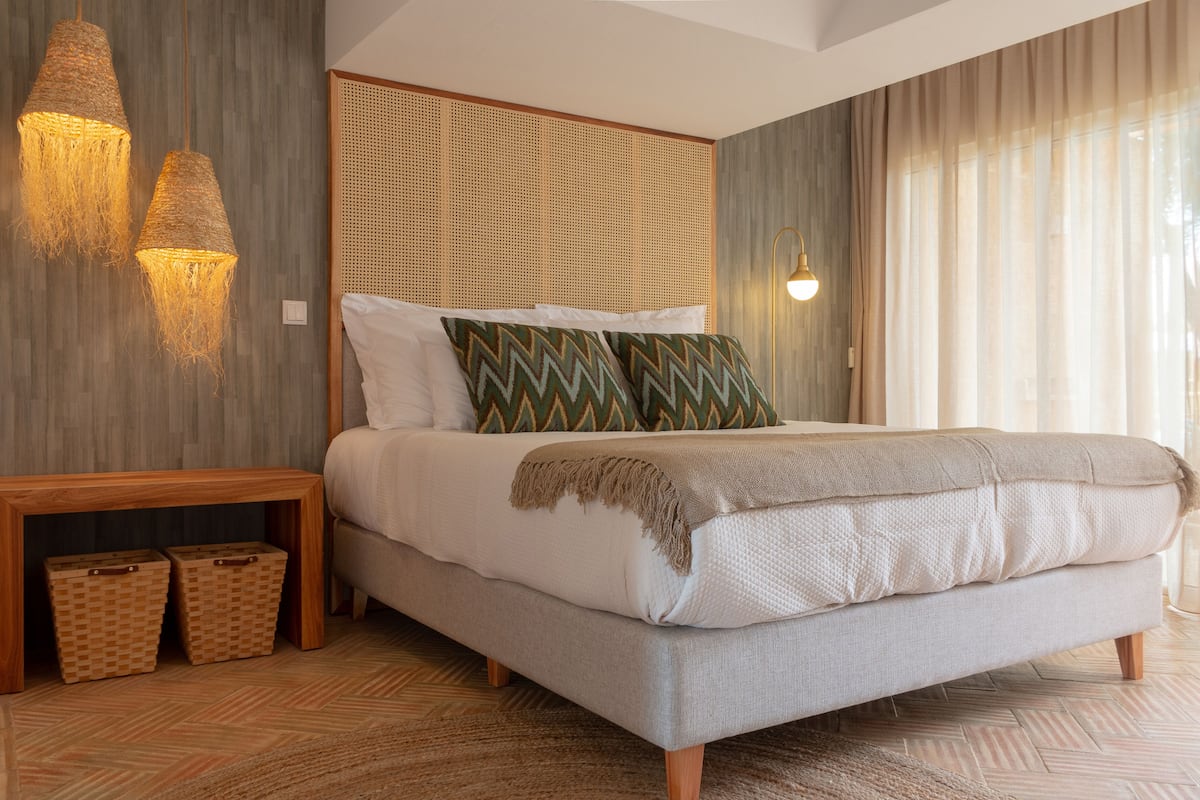 A bedroom with a bed, bedside tables, and a headboard.