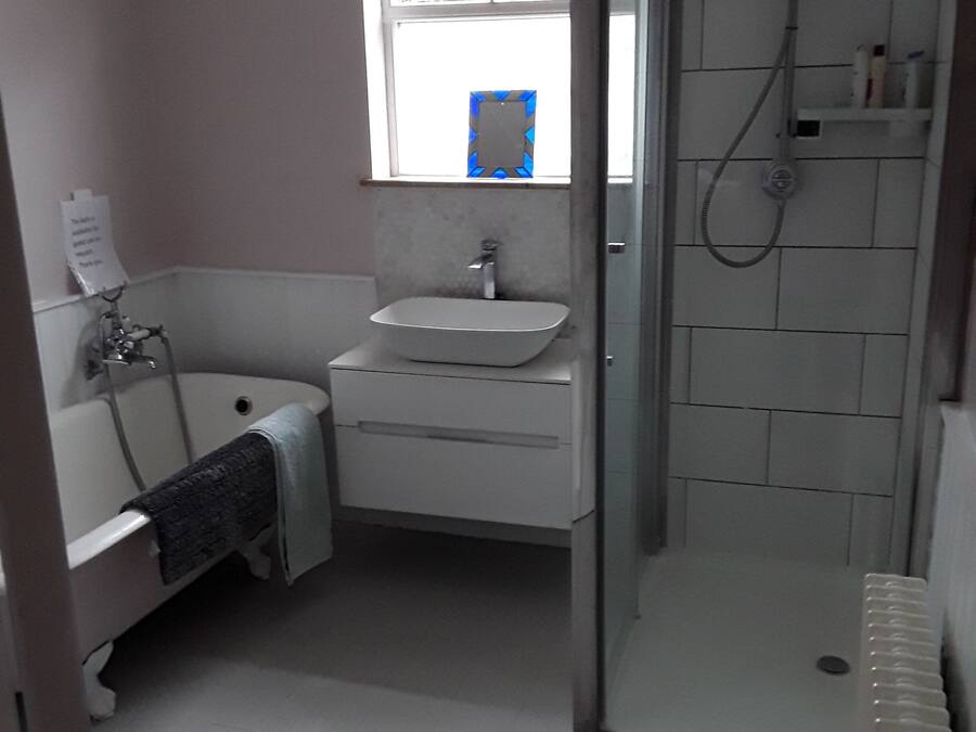 A bathroom with a bathtub, sink, and shower.