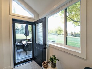 A doorway leading to an outdoor patio with a table and chairs, a potted plant, and a door with a window. - Mountain Modern Retreat - Walk to Park City Mtn - 2 King Suites - Pool & Hot Tub (Park City)