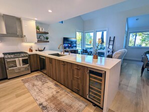 A modern kitchen with a central island, built-in oven, and a large window providing natural light. - Mountain Modern Retreat - Walk to Park City Mtn - 2 King Suites - Pool & Hot Tub (Park City)