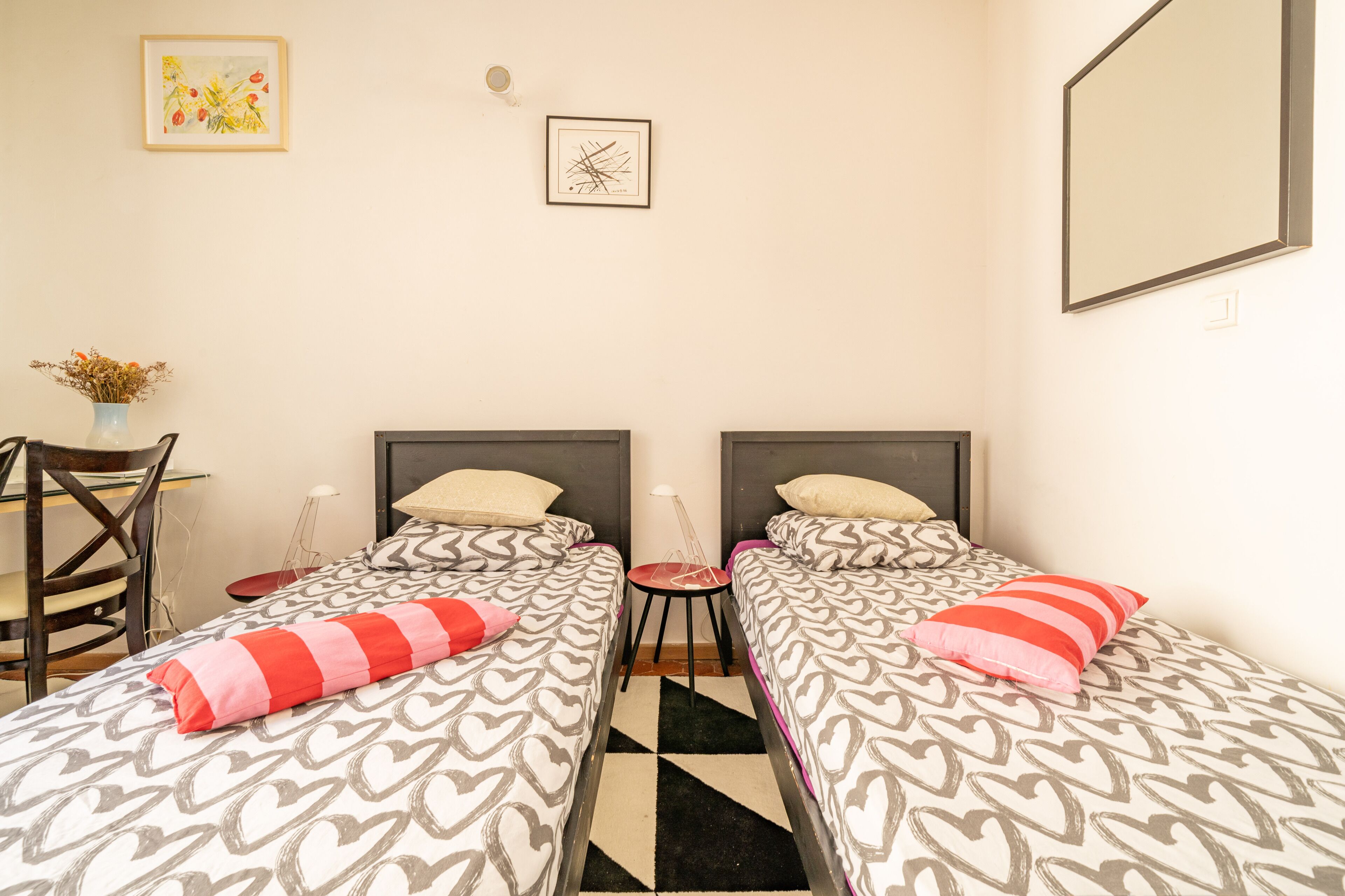 Une chambre avec deux lits, un bureau et une chaise.