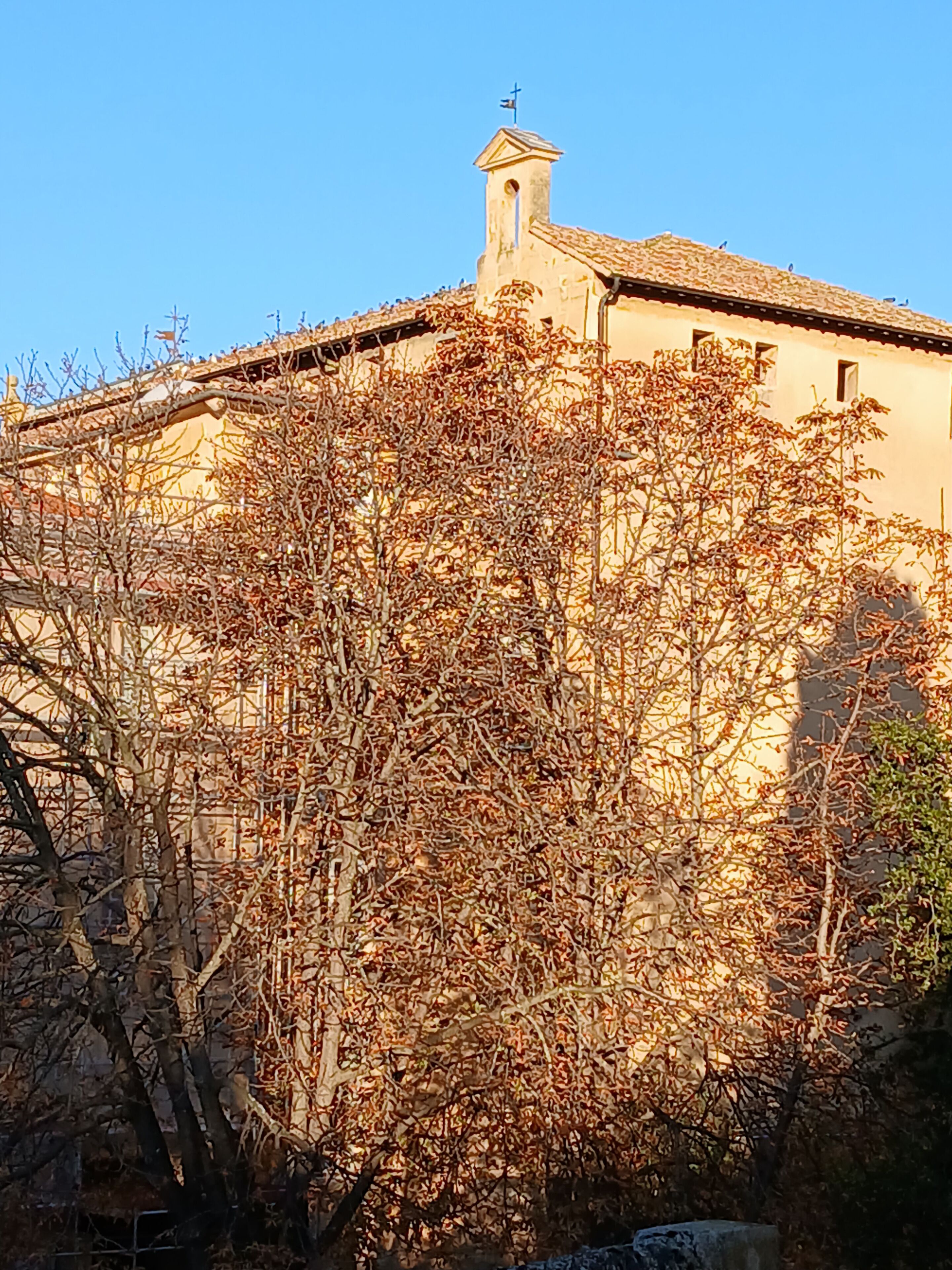 A building with a bell tower and a clear blue sky.