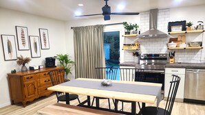 A modern kitchen with a dining area, featuring a wooden table, chairs, and a bench. - Beautiful, Cozy, and Spacious home- 3 mins from downtown (Oberlin)