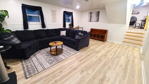 A modern living room with a sectional sofa, a wooden coffee table, and a patterned rug. - Beautiful, Cozy, and Spacious home- 3 mins from downtown (Oberlin)