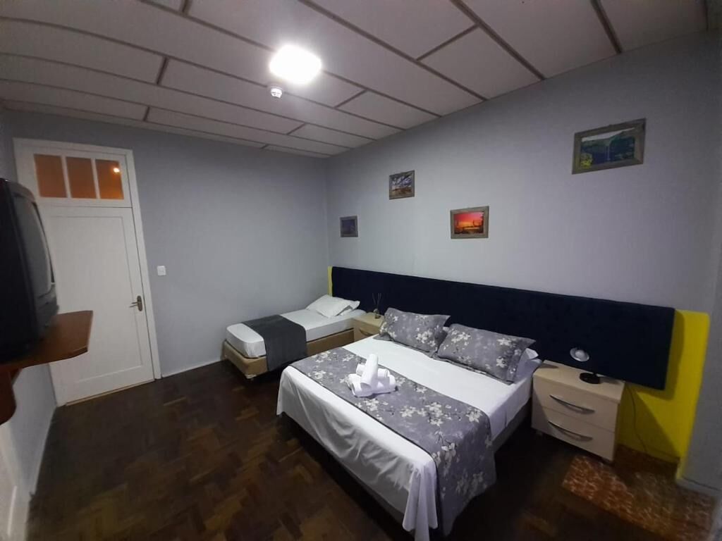 A bedroom with a bed, bedside tables, a wardrobe, and a door.
