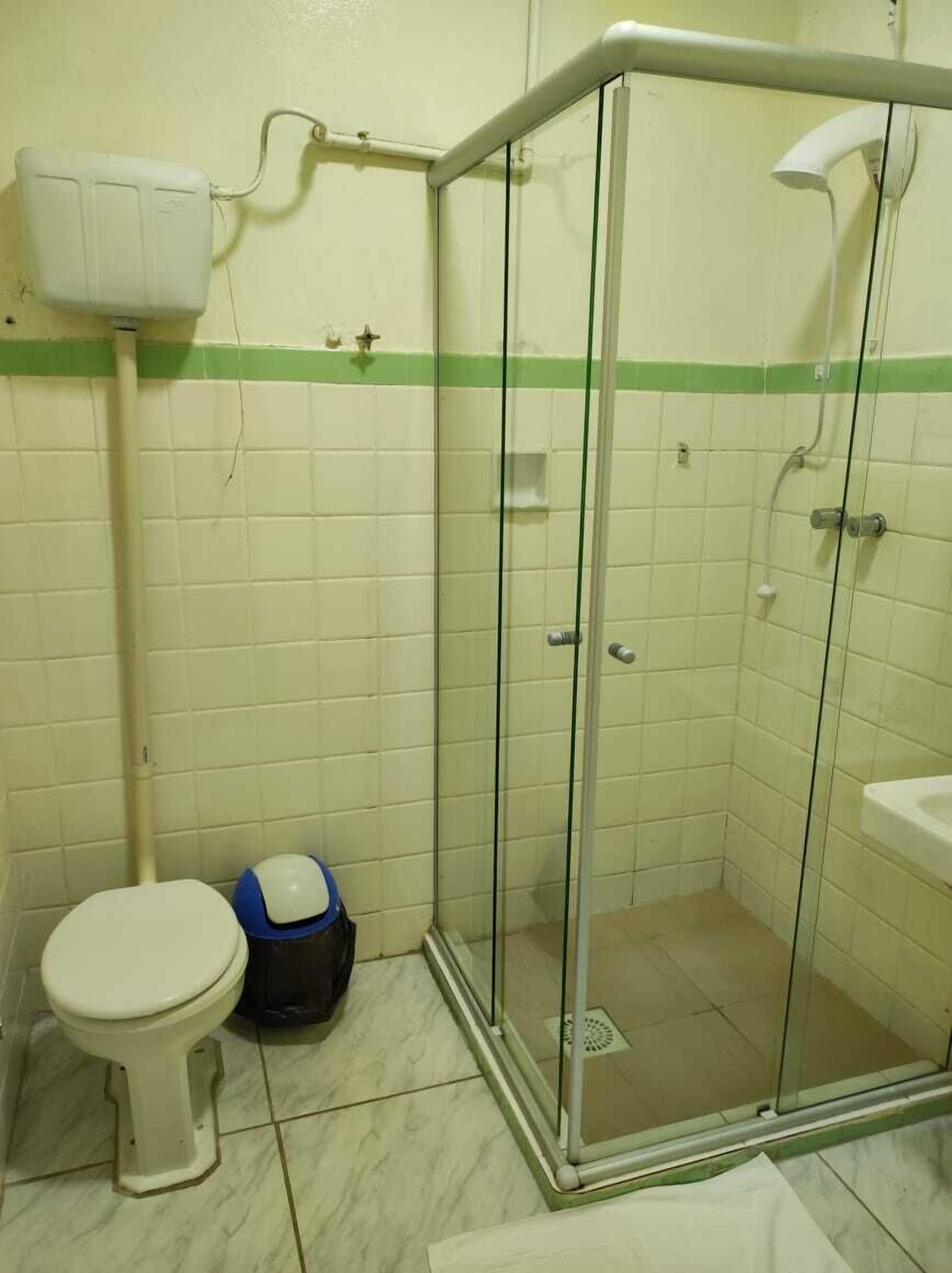 Un bagno piccolo con il water, uno spazio doccia e un lavandino.