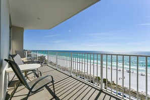 A balcony with a view of the beach and ocean.