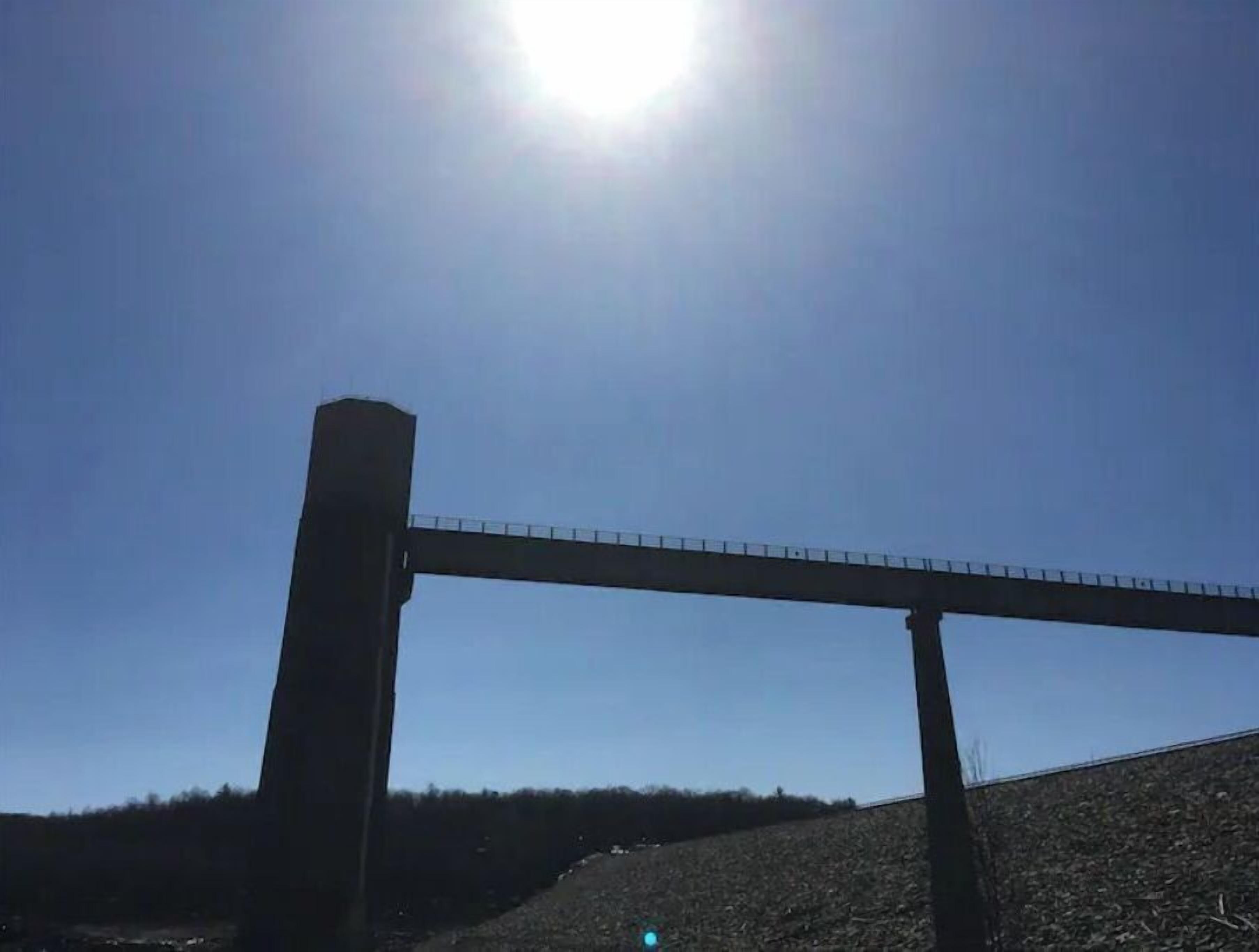 En bro med klar himmel og strålende sol.