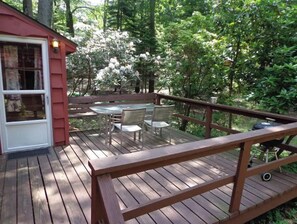 Enjoy dining and socializing on the deck, surrounded by lush greenery and equipped with a barbecue grill.